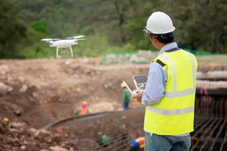 Construction engineer flying drone over-constraction site