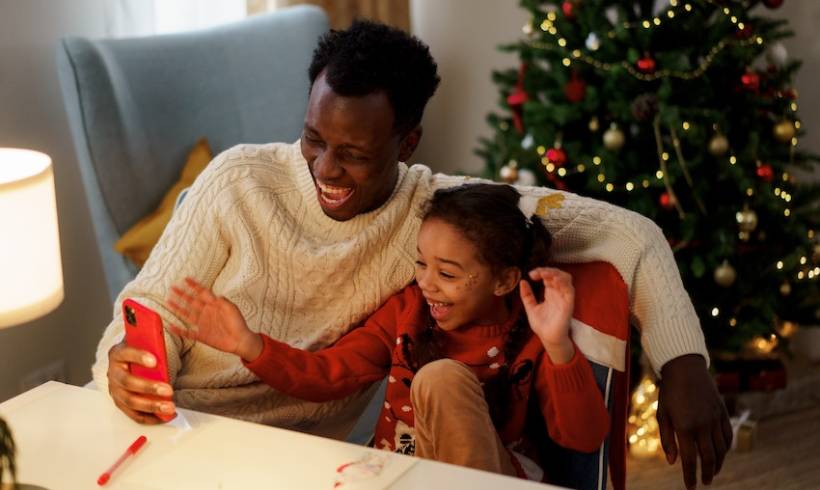 man-daughter-christmas-watching-tv-on-smartphone-memorable-christmas-tv-specials