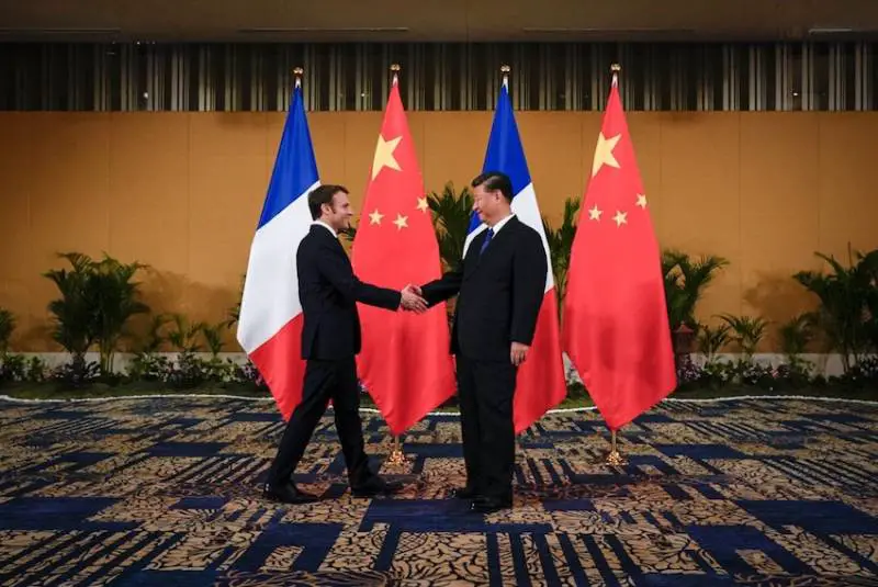 French President Emmanuel Macron shakes hands with Chinese President Xi Jinping