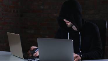 man-hacker-laptop-ai-scam-alert
